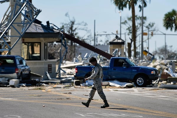 A military police officer walks near a destroyed gate in Tyndall Air Force Base, Fla., in the aftermath of Hurricane Michael on Oct. 12, 2018. (Brendan Smialowski/AFP via Getty Images)