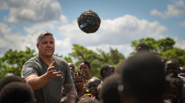 Army Maj. Eric Buendia, assigned to Combined Joint Task Force-Horn of Africa, entertains local Mozambican children in Bebedo, Mozambique, April 8. (Staff Sgt. Corban Lundborg/Air Force)