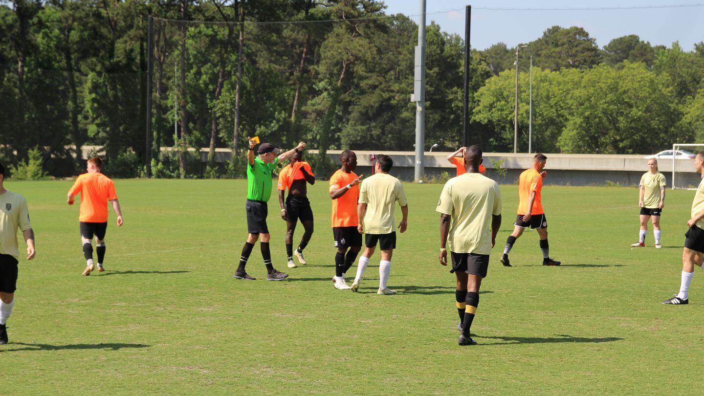 Referee Mike Leone shows the second of two yellow cards to troops from Georgia's Fort Moore and Robins Air Force Base squaring off amid the 2023 Stars Stripes and Soccer Cup at Atlanta United FC's training facility in Marietta, Georgia, on June 3. (Davis Winkie/Staff)