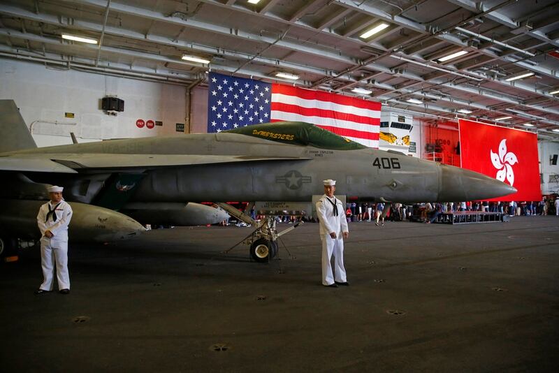 An American flag and Hong Kong flag are seen inside the U.S. Navy's Ronald Reagan aircraft carrier In Hong Kong, Wednesday. The Reagan docked in Hong Kong on Wednesday, days after a pair of American B-52 bombers flew over the disputed South China Sea. (Kin Cheung/AP)