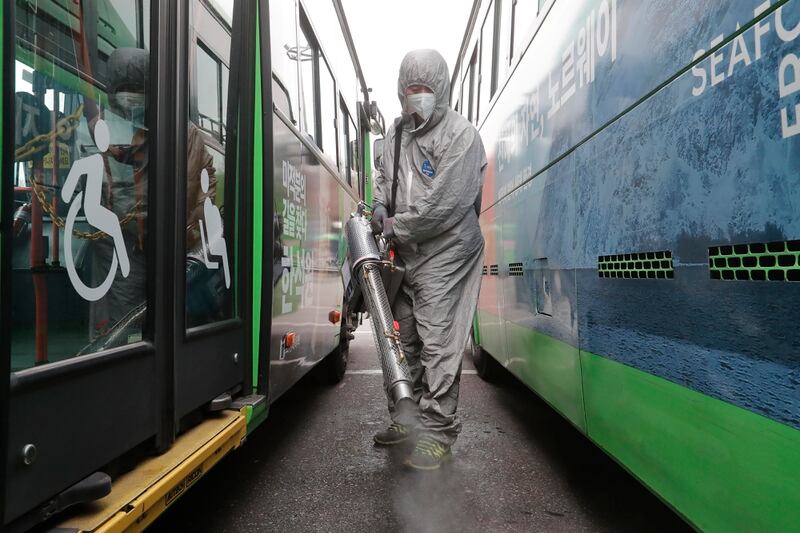 A worker wearing a protective suit sprays disinfectant as a precaution against the coronavirus at a bus garage in Seoul, South Korea, Wednesday, Feb. 26, 2020. (Ahn Young-joon/AP)