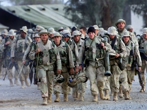 In this Dec. 31, 2001, file photo, U.S. Marines with full battle gear prepare to leave the U.S. military compound at Kandahar airport for a mission to an undisclosed location. (John Moore/AP)