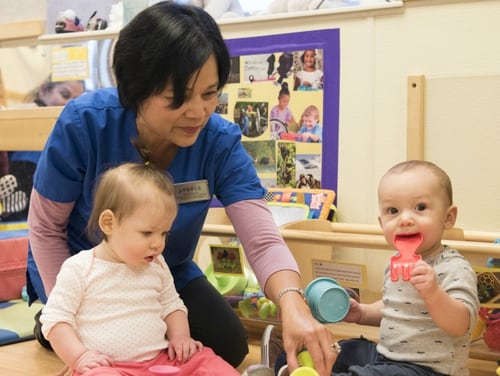 Nelia McKeown, a Sitka Child Development Center child and youth program assistant, gives children toys to play with during playtime at Joint Base Elmendorf-Richardson, Alaska, Dec. 14, 2018. Service officials told lawmakers this week that daycare availability on military bases directly effects troops' readiness. (Airman 1st Class Crystal A. Jenkins/Air Force)