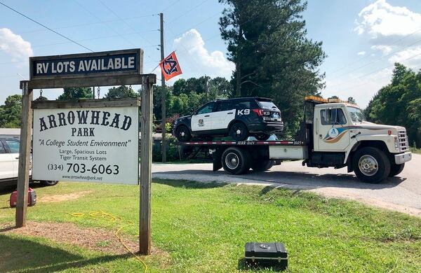 A tow truck removes a police car from a mobile home park, Monday, May 20, 2019, in Auburn, Ala., where three police officers were shot late Sunday. Authorities say a man opened fire on police responding to a domestic call late Sunday, killing one officer and wounding two others. (Blake Paterson/AP)