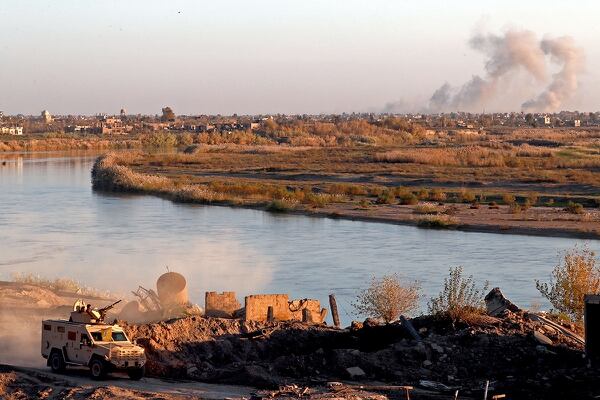 Smoke billows after bombings in the Deir Ezzor province as a vehicle of the Syrian Democratic Forces (SDF) stops in Hajin, in the Deir Ezzor province, eastern Syria, on Dec. 15, 2018. (Delil Souleiman/AFP via Getty Images)