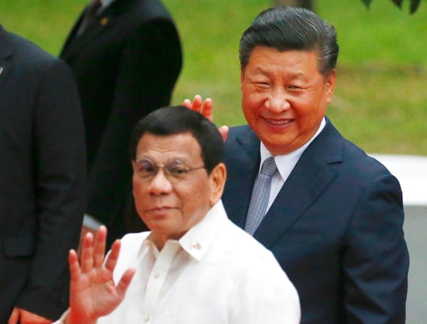 Chinese President Xi Jinping, right, and Philippine President Rodrigo Duterte wave to the media following a welcome ceremony at Malacanang Palace in Manila, Philippines. During Xi’s visit the Philippines, the sides signed a 