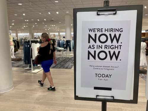 A customer walks behind a sign at a Nordstrom store seeking employees in Coral Gables, Fla., on May 21. (Marta Lavandier/AP)