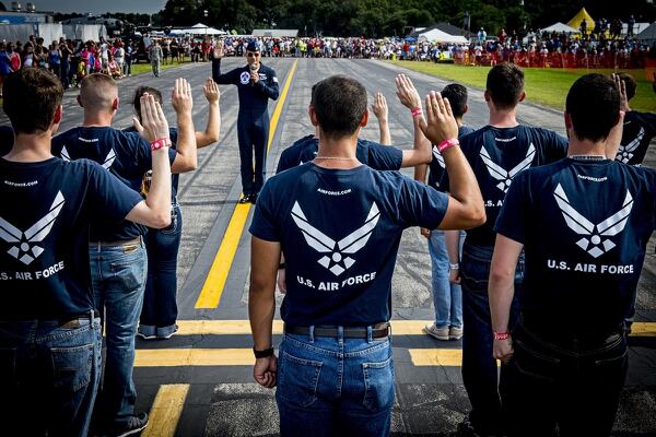 Maj. Tyler Ellison, an Air Force Thunderbirds pilot, administers the Oath of Enlistment to a group of new airmen during an air show in Florida. (Tech. Sgt. Manuel J. Martinez/Air Force)