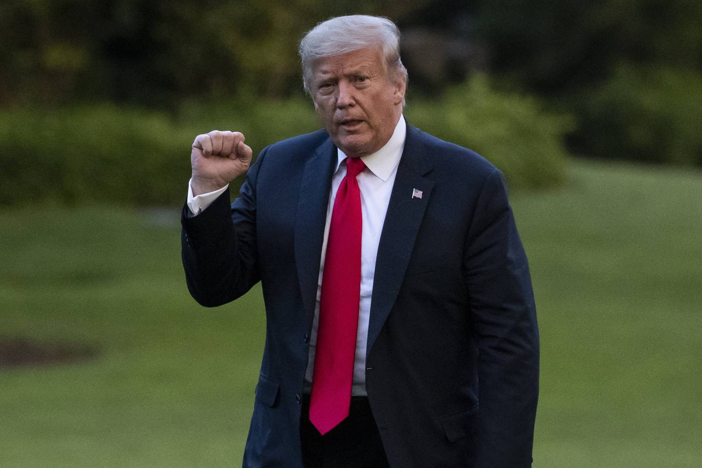 President Donald Trump pumps his fist as he walks on the South Lawn after arriving on Marine One at the White House on June 25, 2020, in Washington.
