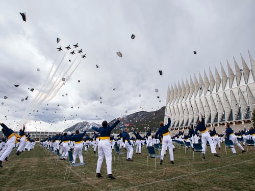 The class of 2020 toss their caps into the air as the Thunderbirds fly over Saturday, April 18, 2020, at the conclusion of the Air Force Academy graduation in Colorado Springs, Colo. Nearly 1,000 cadets graduated in a scaled-down ceremony due to the coronavirus pandemic. Saturday's commencement was attended by Vice President Mike Pence and capped a difficult final semester in which the cadets attended virtual classes and ate their meals alone in dorm rooms. (Christian Murdock/The Gazette via AP)
