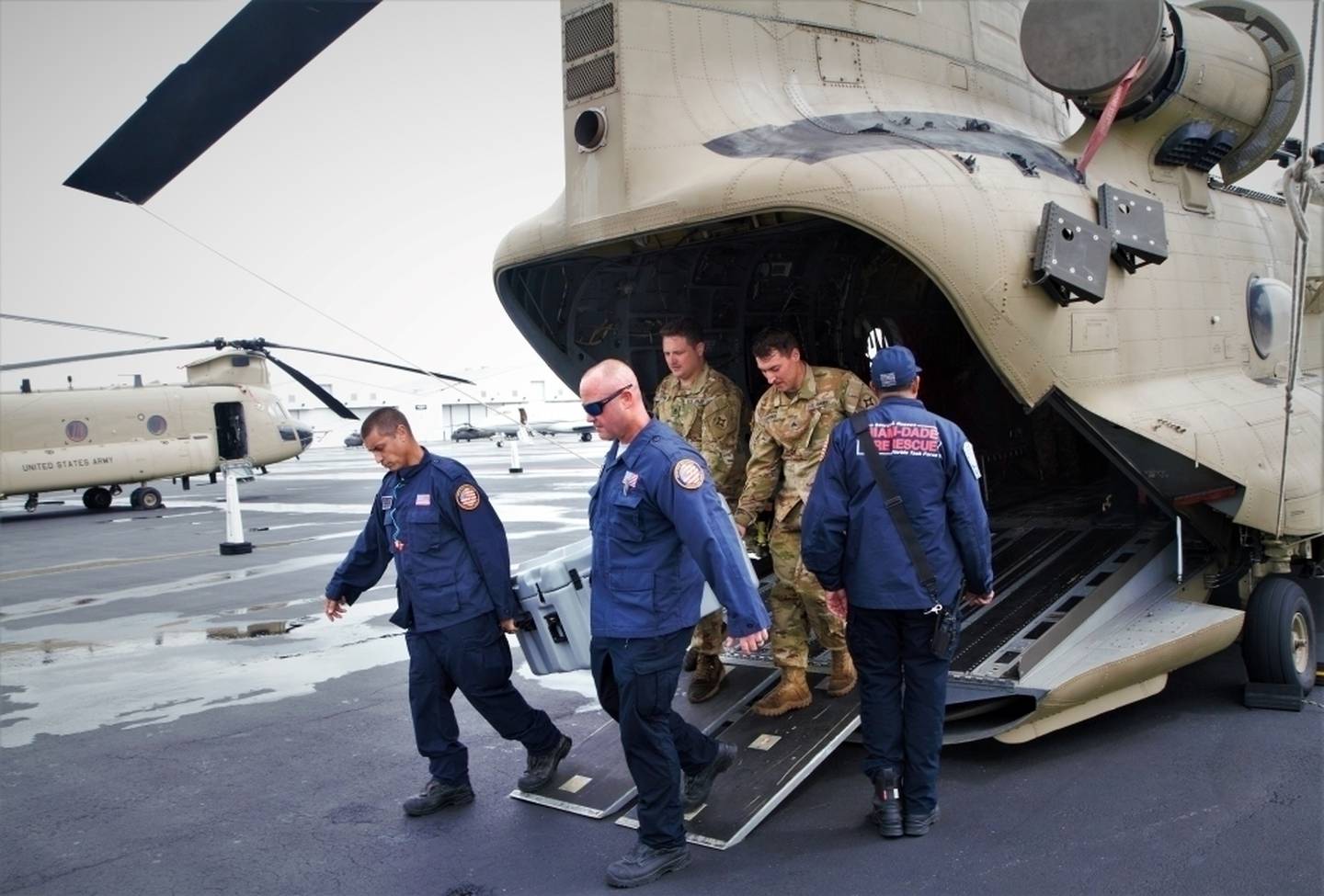 Soldiers practice loading and unloading operations on a CH-47F Chinook helicopter with helicopter search-and-rescue team members of Florida Task Force 1 at Opa-locka, Florida, on Sept. 28, 2022.