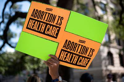An abortion rights demonstrator holds a sign outside of the Harris County Courthouse during the Women's Wave march in Houston, Texas, on October 8, 2022.