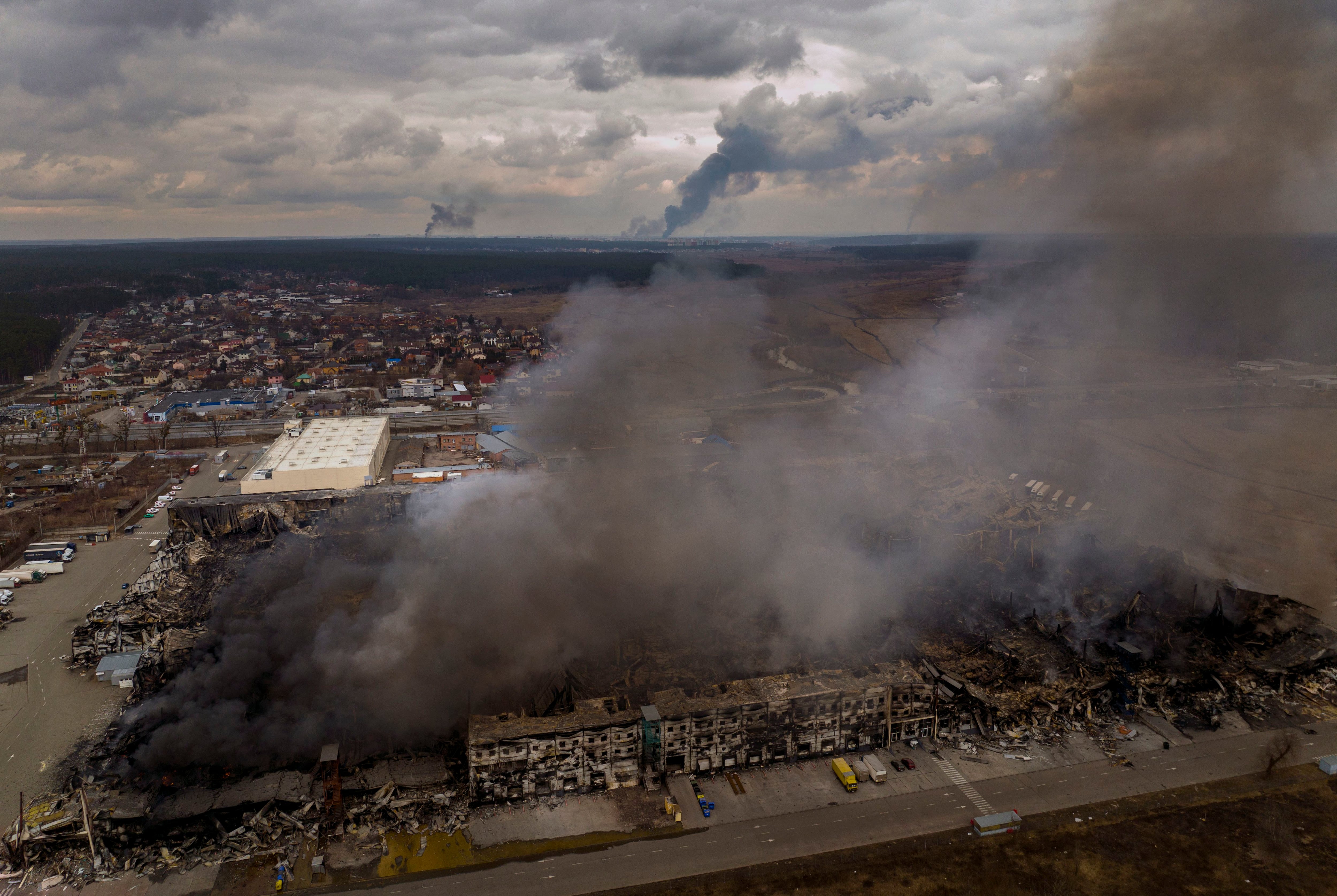 A factory and a store are burning after been bombarded in Irpin, in the outskirts of Kyiv, Ukraine, Sunday, March 6, 2022. (Emilio Morenatti/AP)
