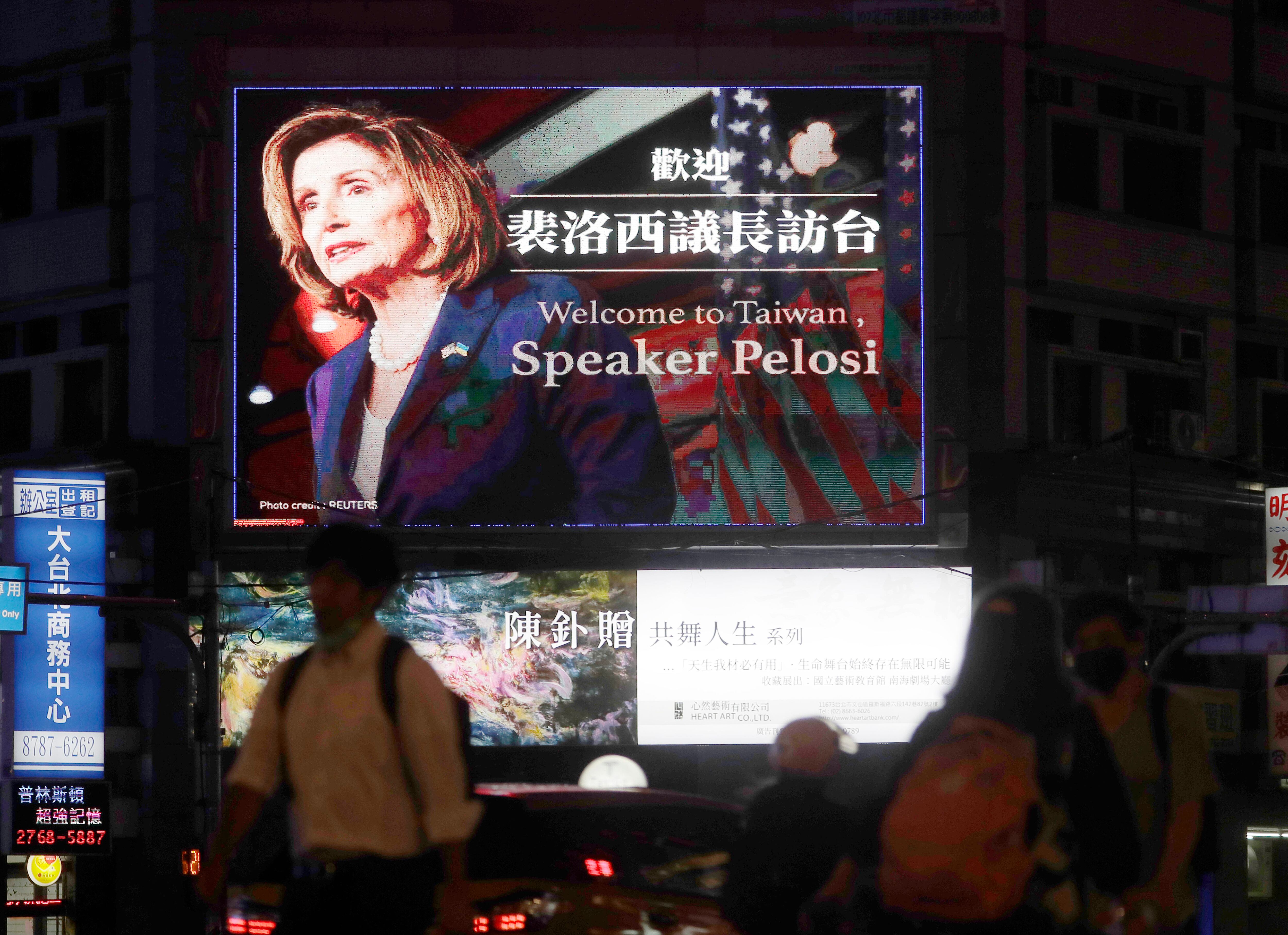 People walk past a billboard welcoming U.S. House Speaker Nancy Pelosi, in Taipei, Taiwan, Tuesday, Aug 2, 2022. (Chiang Ying-ying/AP)