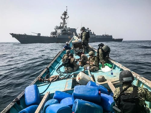 A team from the guided-missile destroyer USS Jason Dunham inspects a dhow while conducting maritime security operations. A U.S. military video released Aug. 31, 2018, purported to show small ships in the Gulf of Aden smuggling weapons amid the ongoing war in Yemen, with officials saying they seized over 2,500 arms from the vessels. (U.S. Navy via AP)