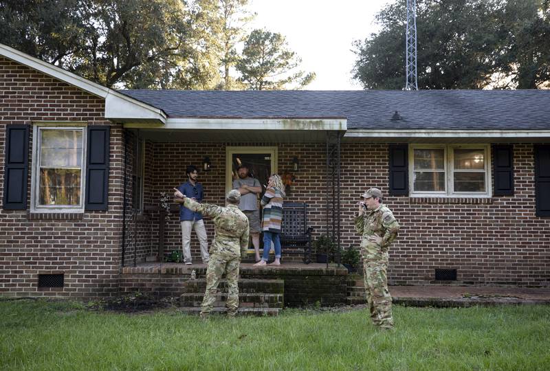 Airmen from Joint Base Charleston speak to a family living right next to the site of a crashed F-35 about the operation to recover the fighter jet and requests for the family in Williamsburg County, S.C., on Monday, Sept. 18, 2023.