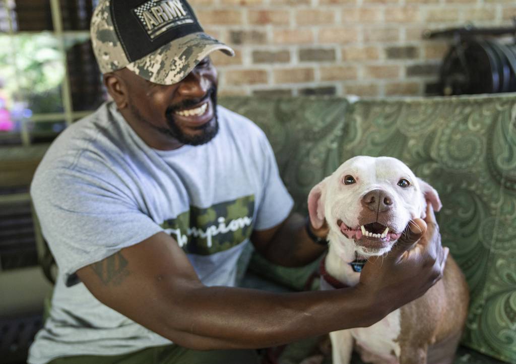 Omar Brooks pets Maisie Mae, a foster dog at Bridge To Home Animal Rescue on Monday, July 6, 2020, in Eighty Four, Pa.