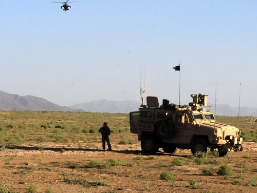 Coalition forces provide security while an American Apache helicopter flies overhead in an attempt to locate insurgents who reportedly placed a roadside bomb in Shinkay district of Zabul province in Afghanistan on April 22. 2020. (Sgt. Debra Richardson/Army)