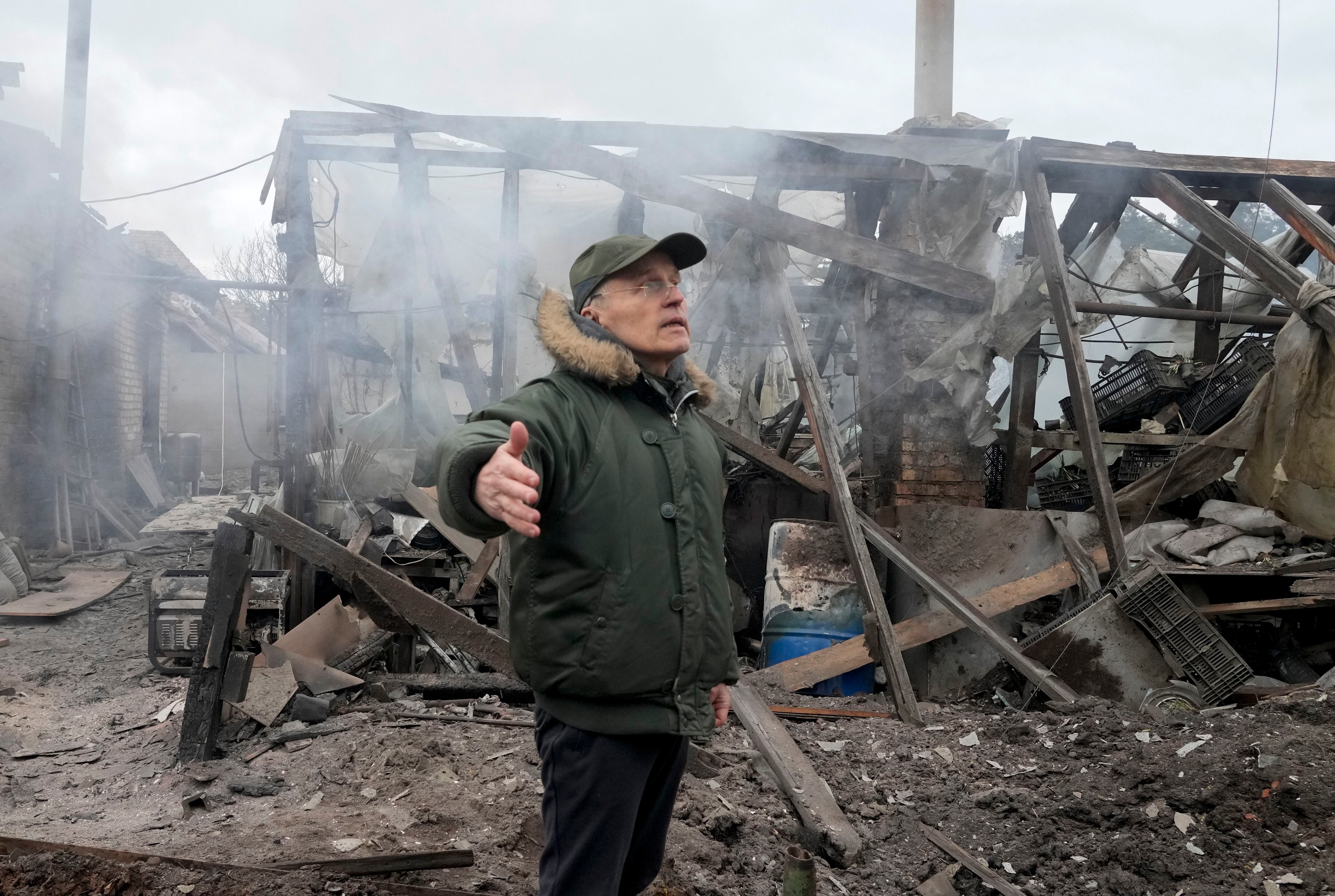 A man opens his arms as he stands near a house destroyed in the Russian artillery shelling, in the village of Horenka close to Kyiv, Ukraine, Sunday, March 6, 2022. On Day 11 of Russia's war on Ukraine, Russian troops shelled encircled cities, and it appeared that a second attempt to evacuate civilians from the besieged port city of Mariupol had failed due to continued violence. (AP Photo/Efrem Lukatsky)