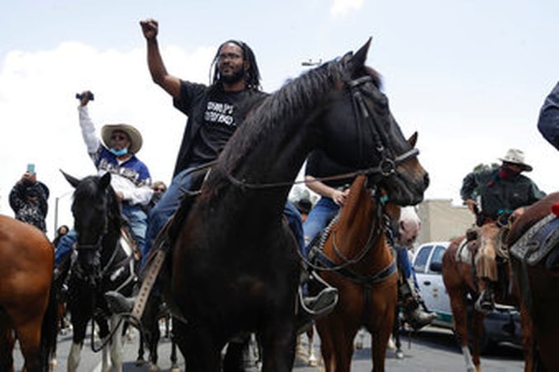 Members of the Compton Cowboys join a demonstration Sunday June, 7, 2020 in Compton, Calif., during a protest over the death of George Floyd who died May 25 after he was restrained by Minneapolis police. (AP Photo/Marcio Jose Sanchez)