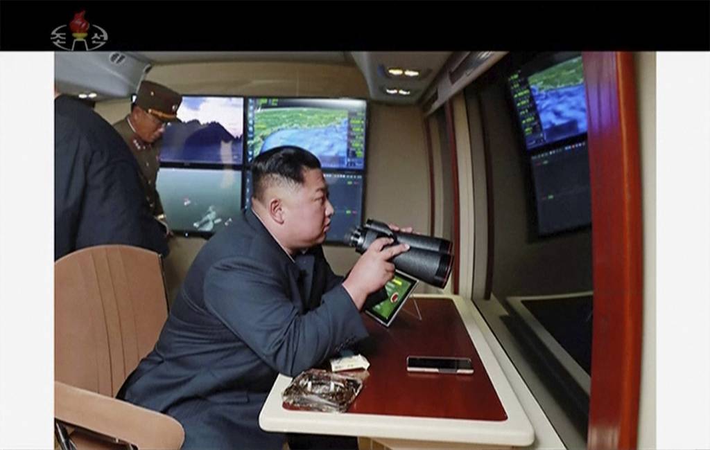 North Korean leader Kim Jong Un, equipped with binoculars, supervises a rocket launch test on Aug. 1, 2019.