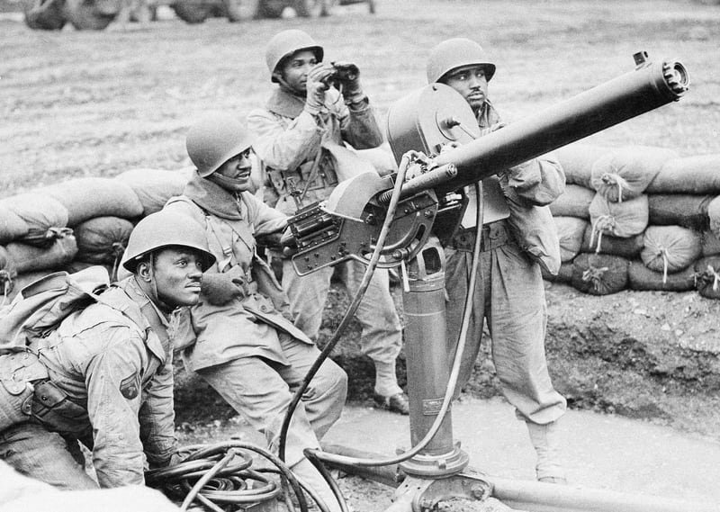 Some of the African American troops manning an anti-aircraft gun on an airfield under construction, somewhere in England, April 12, 1943. Left to right are: T5 Jesse James Draugham, from Bremond, Texas; Private Howard Kibble, from Chicago; acting Sergeant Howell Atkinson, from Fort Worth, Texas, and Private 1st Class, John Brown, from Steucanville, Ohio. (AP Photo)