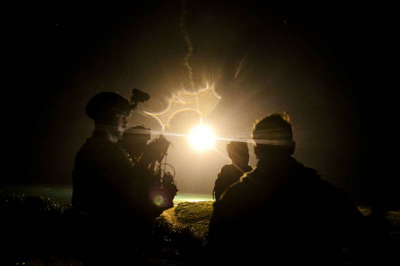 U.S. Marines watch illuminating rounds during a simulated close-air support and assault support training event at W-174, Okinawa, Japan, Aug. 18, 2020.