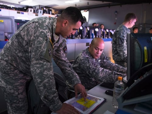 U.S. Army Capt. Otis Ingram explains predictions of space interference to a fellow Army officer March 10, 2015, in the Republic of Korea Air and Space Operation Center during exercise Key Resolve at Osan Air Base, Republic of Korea. Ingram is a space coordination officer from the 3rd Battlefield Coordination Detachment. (U.S. Air Force photo by Staff Sgt. Shawn Nickel/Released)
