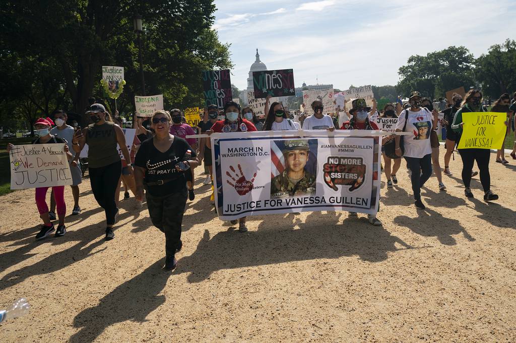 Supporters of the family of slain Army Spc. Vanessa Guillen march to the White House along the National Mall as Capitol Hill is seen in the distance after a news conference, Thursday, July 30, 2020, in Washington.