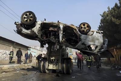In this Jan. 10, 2021, file photo, Afghan security personnel remove a damaged vehicle after a deadly roadside bomb attack in Kabul, Afghanistan.