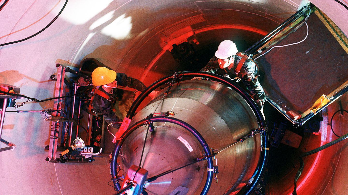 Maintenance personnel with the 321st Strategic Missile Wing guide the reentry system for an LGM-30 Minuteman III missile onto a missile guidance set in 1990. (U.S. Air Force)