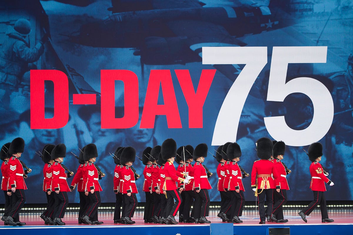 An honor guard marches on stage during a ceremony to mark the 75th Anniversary of D-Day,