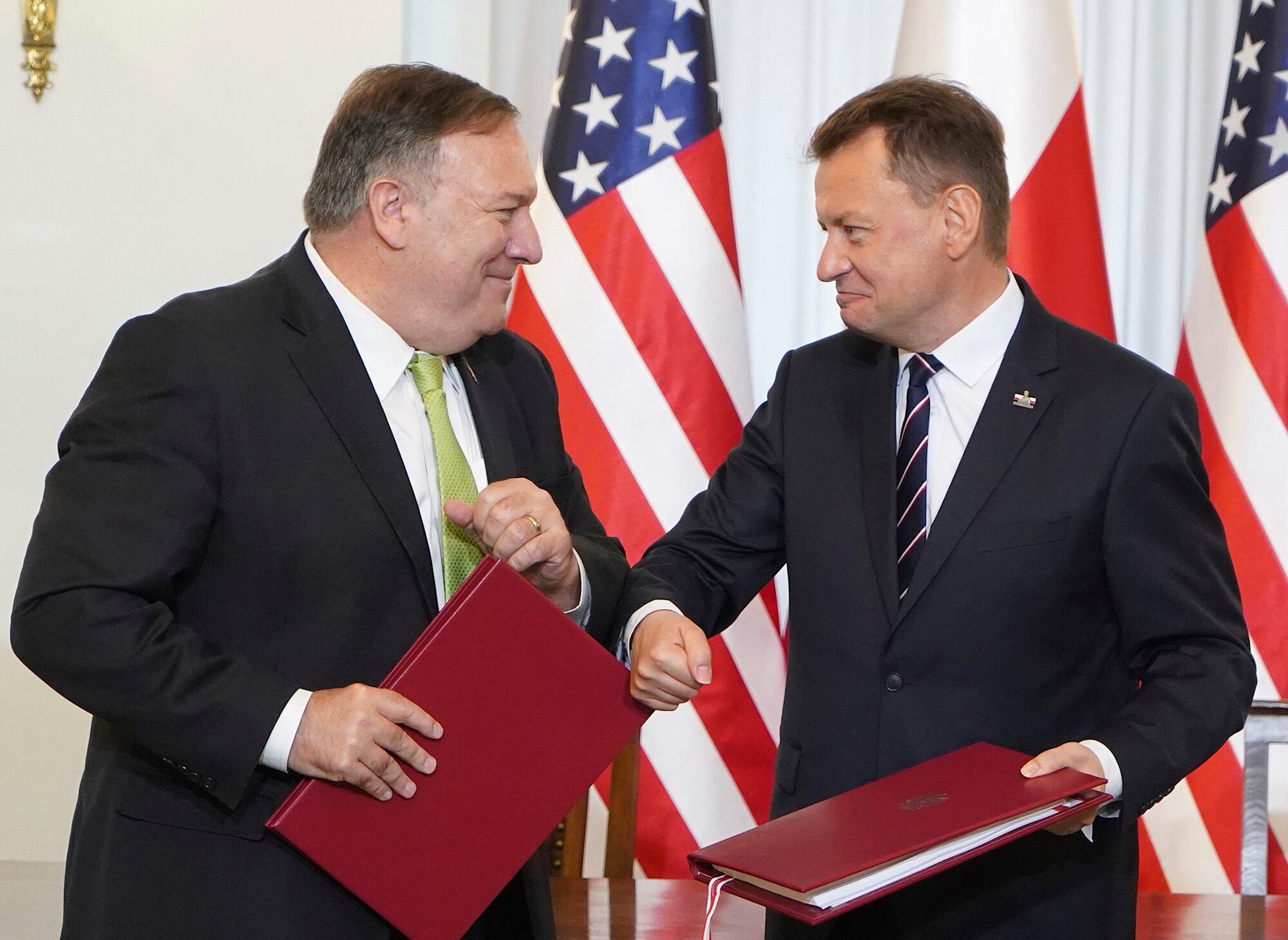 U.S. Secretary of State Mike Pompeo, left, and Poland's Minister of Defence Mariusz Blaszczak greet each other after signing the US-Poland Enhanced Defence Cooperation Agreement in the Presidential Palace in Warsaw, Poland, Saturday Aug. 15, 2020.