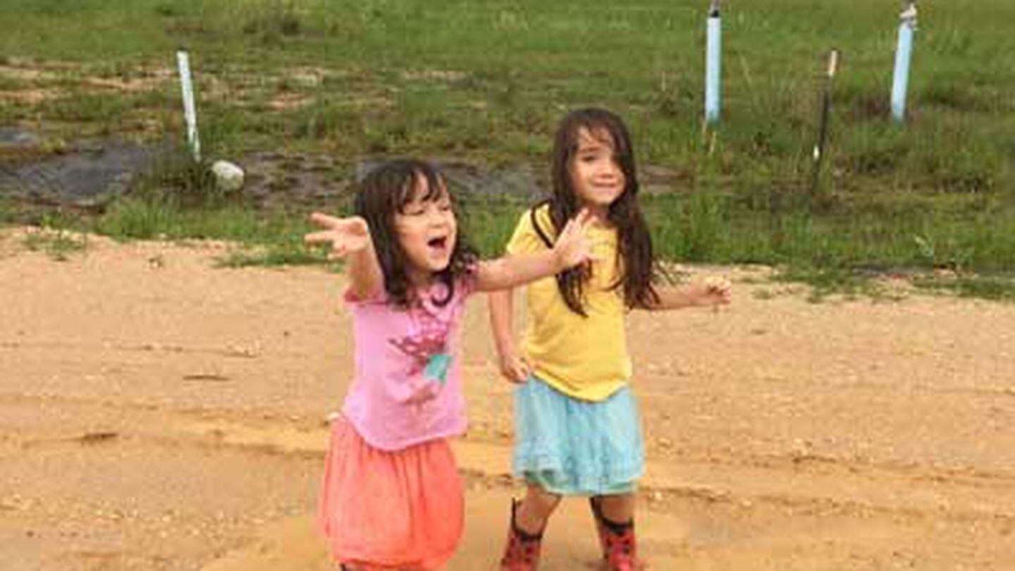 Rori and Katalina Rathbun, playing in the rain, April 2016. “I missed being a parent with him,” writes Andrea Rathbun of her husband’s deployments. Photo courtesy of the author.