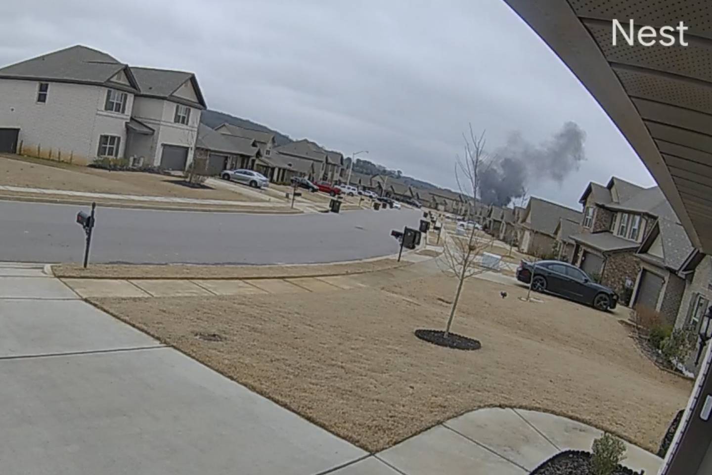 In this image made from video taken from a Nest camera provided by Mia McShan, a cloud of black smoke rises from where a Black Hawk helicopter crashed on Wednesday, Feb. 15, 2023, in Alabama.