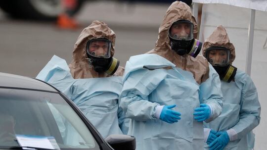Colorado National Guard medical personnel prepare to perform coronavirus test on a motorist at a drive-through testing site outside the Denver Coliseum on Saturday in Denver. Officials planned to administer 150 tests but the line of vehicles wrapped around three city blocks. (David Zalubowski/AP)
