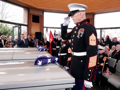 In this Jan. 17, 2019, photo, a retired U.S. Marine master gunnery sergeant salutes three Memphis veterans, Wesley Russell, 76, Arnold Klechka, 71, Charles Fox, 60, who died this past fall and whose remains were unclaimed, in Memphis, Tenn. (Karen Pulfer Focht/AP)