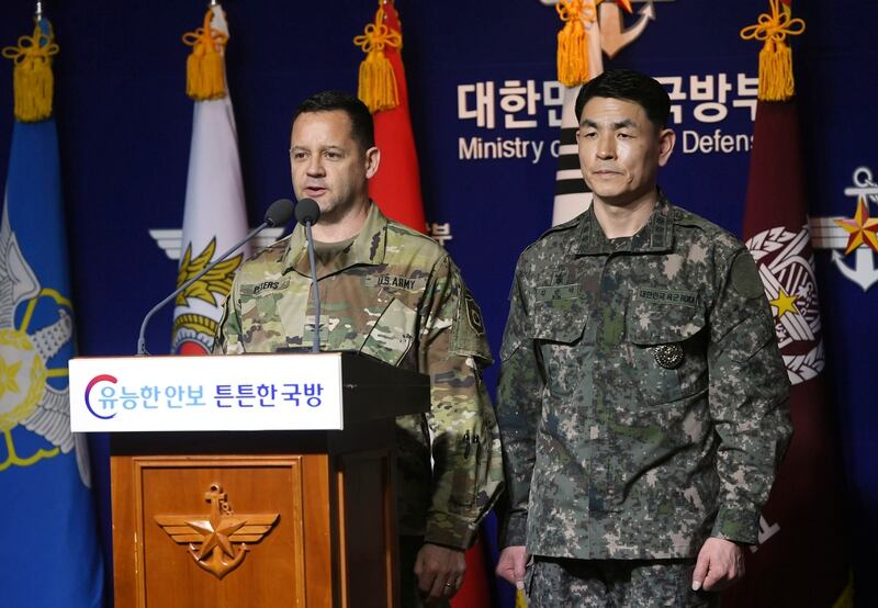 U.S. Army's Col. Lee Peters, director of Public Affairs of United States Forces Korea, and Col. Kim Jun-rak, of South Korea's Joint Chiefs of Staff, brief the media about postponed joint military drills at Defense Ministry in Seoul, South Korea, Thursday, Feb. 27, 2020. (Korea Pool/Yonhap via AP)