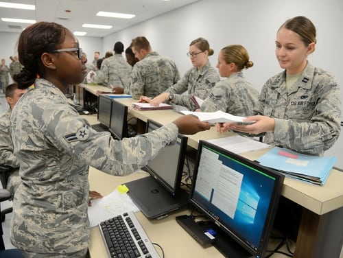 Airman 1st Class Maiesha Buford gives Capt. Theresa Hall her health records during a deployment preparation exercise on Oct. 4, 2017, at Tinker Air Force Base in Oklahoma. The Department of Veterans Affairs last year finalized a 10-year, $16-billion plan to share medical records systems with the Department of Defense. (Kelly White/Air Force)