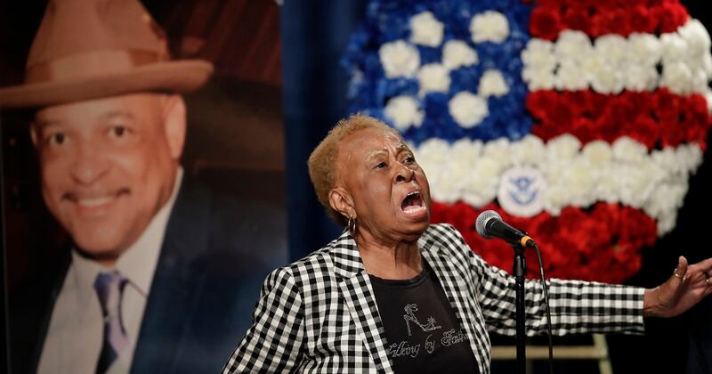 Janie Taylor sings beside a photo of Federal Protective Services Officer Dave Patrick Underwood on June 19, 2020, in Pinole, Calif. Underwood was fatally shot as he was guarding the Ronald V. Dellums Federal Building in Oakland, Calif., on May 29. (Ben Margot/AP)