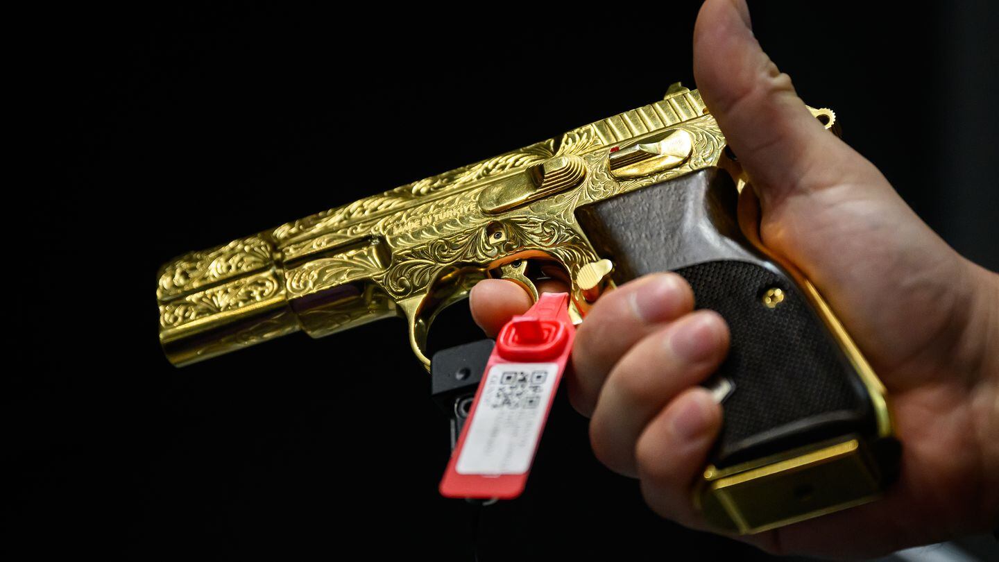 A man handles a gold Kilinc 2000 Light 9mm handgun on the Sig Sauer stand at DSEI on Sept. 12, 2023, in London. (Leon Neal/Getty Images)