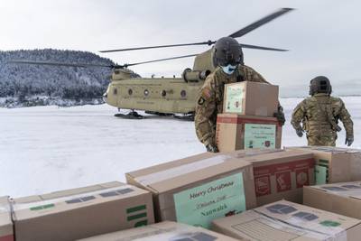 Soldiers unload gifts from a CH-47 Chinook helicopter in Nanwalek, Alaska, during Operation Santa Claus, on Dec. 11, 2020.