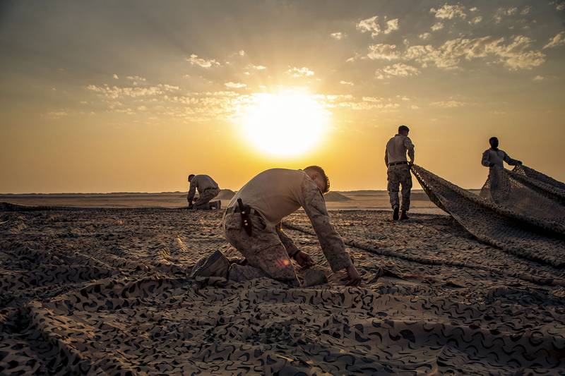 U.S. Marines with Special Purpose Marine Air-Ground Task Force Crisis Response - Central Command 20.2, assemble a camouflage canopy before a demolition range in Kuwait, Aug. 31, 2020.
