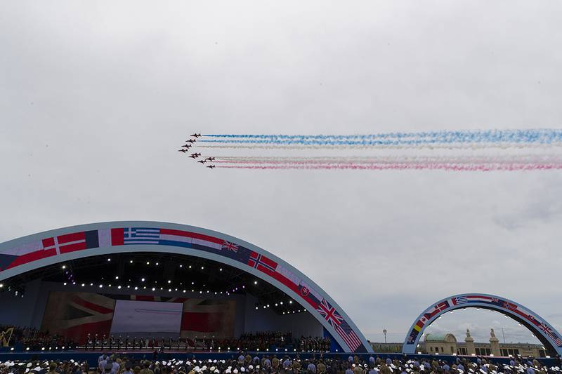 A flyover trails colored smoke to conclude a ceremony to mark the 75th Anniversary of D-Day