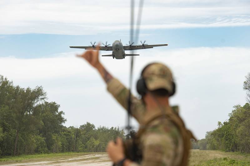 Air Force Capt. Gene Walker waves on a C-130J Super Hercules as it approaches the landing zone during Cope North 21, Feb. 11, 2021, on Angaur, Palau.